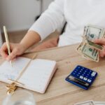 Photo by https://kaboompics.com/: https://www.pexels.com/photo/person-writing-on-a-notebook-while-holding-money-5900184/