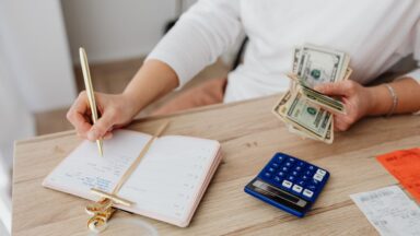 Photo by https://kaboompics.com/: https://www.pexels.com/photo/person-writing-on-a-notebook-while-holding-money-5900184/