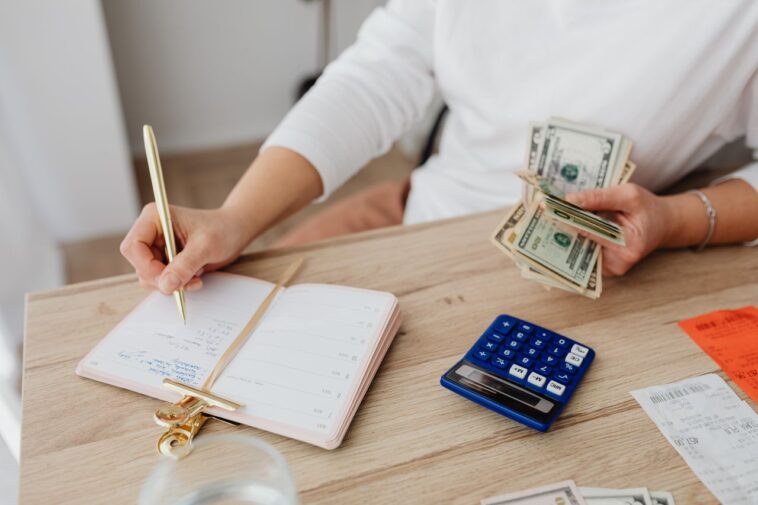 Photo by https://kaboompics.com/: https://www.pexels.com/photo/person-writing-on-a-notebook-while-holding-money-5900184/